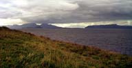 Ardnamurchan point. In the background, blessed with a ray of sun are probably the Cuillins hills